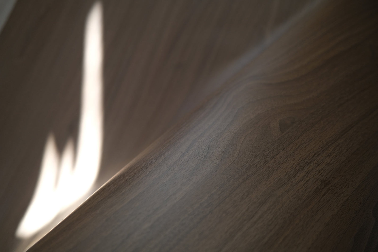 Premium walnut wood grain finish over a wrapped edge in soft window light