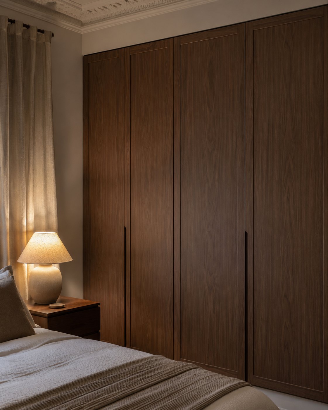 Tall walnut wardrobe door fronts with crisp clean edges in a warm bedroom