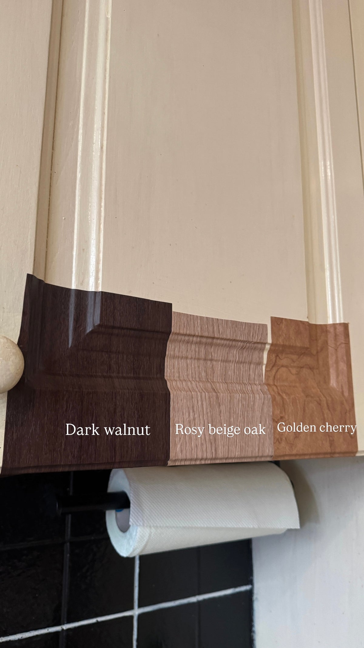 Three Velven samples, Dark Walnut, a rosy beige oak and Golden Cherry, held across a cream cabinet door