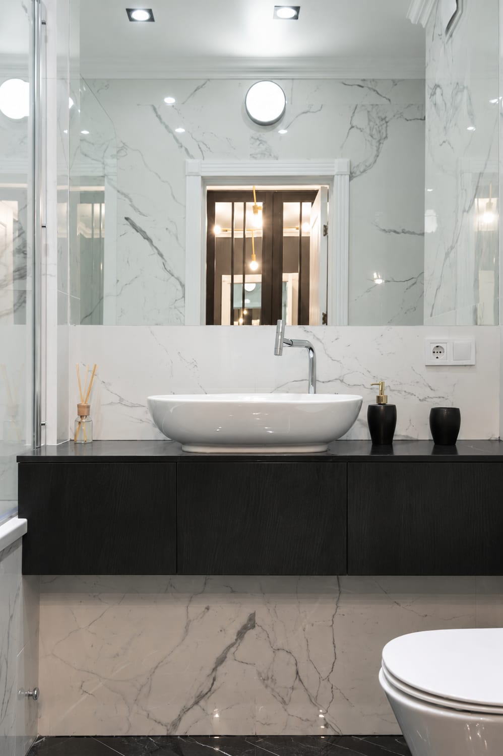 A floating vanity wrapped in near black Kuro Sumi against white marble