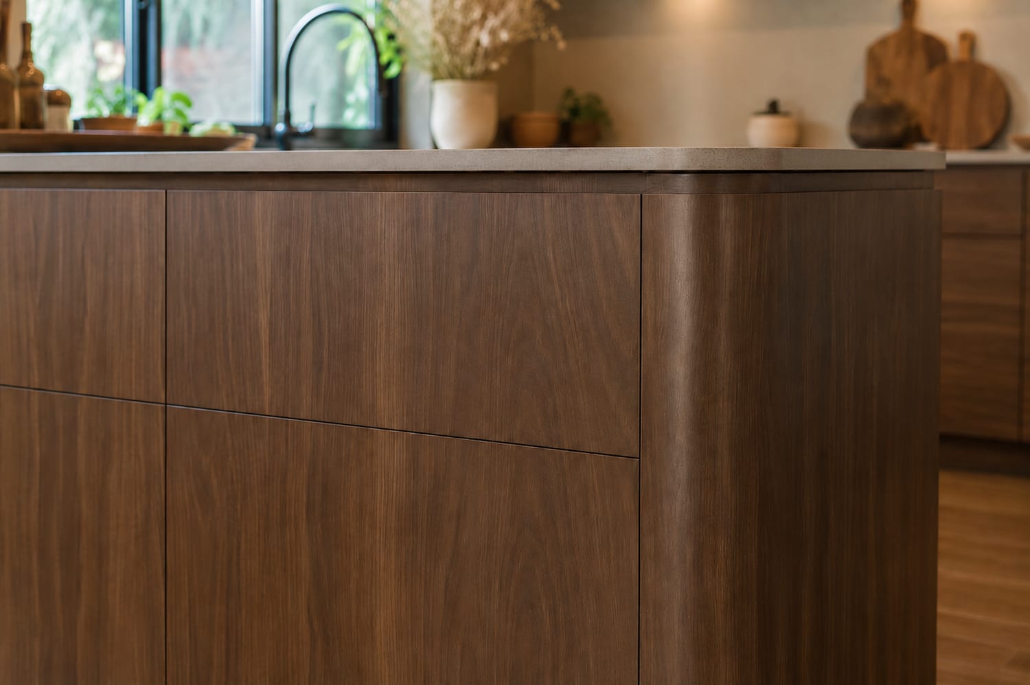 A close view of a kitchen island wrapped in Castello Walnut with a waterfall edge
