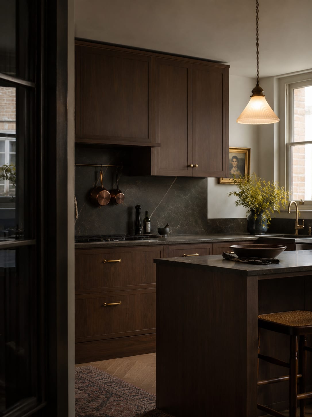 A kitchen at dusk with cabinets wrapped in Castello Walnut
