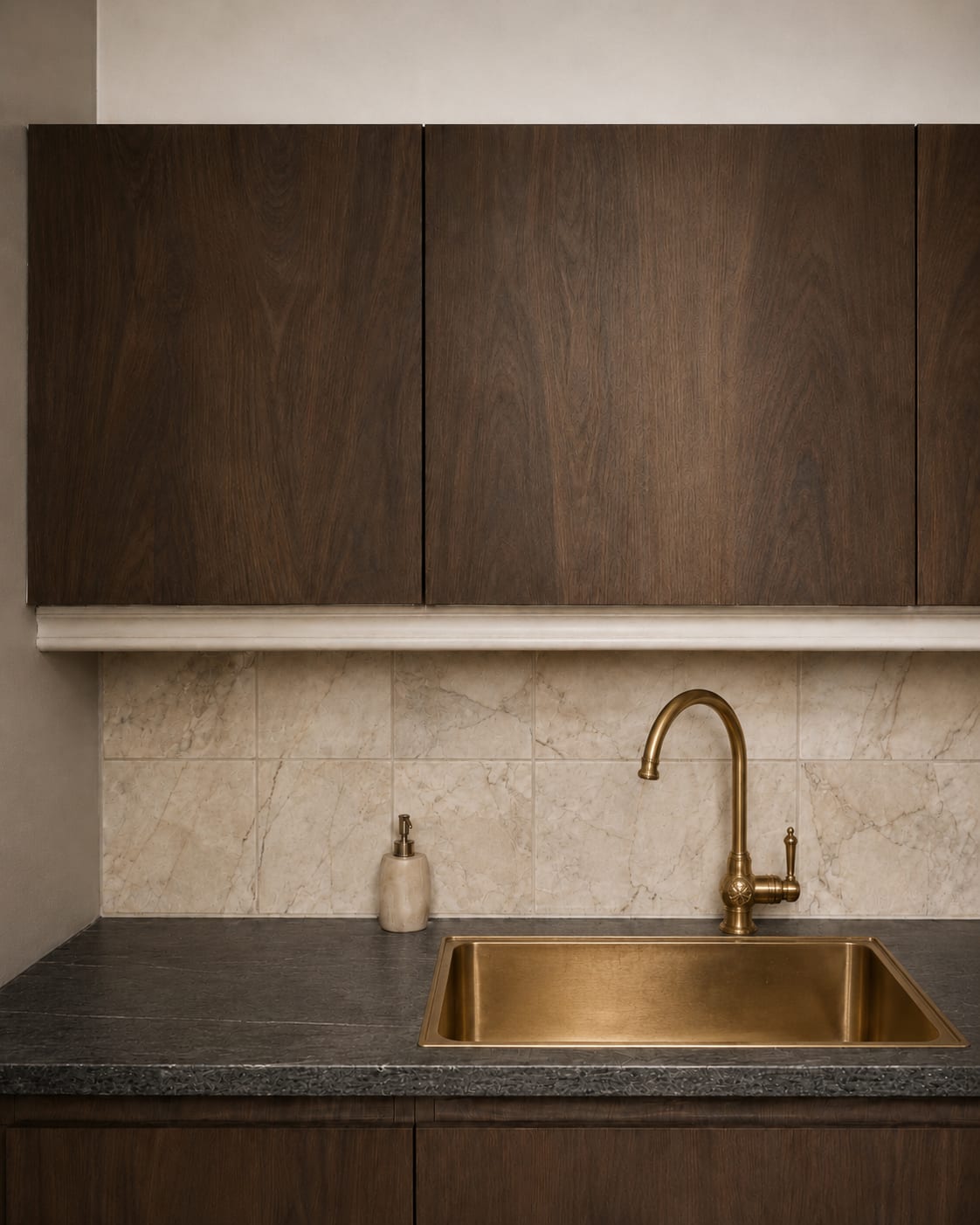 A close view of walnut wrapped cabinets with a brass bar sink and marble splashback