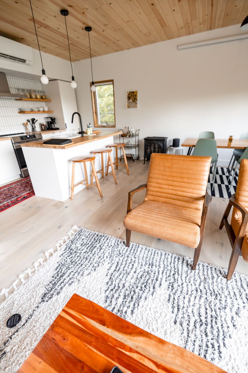 An open plan kitchen with an island wrapped in Sereno Oak