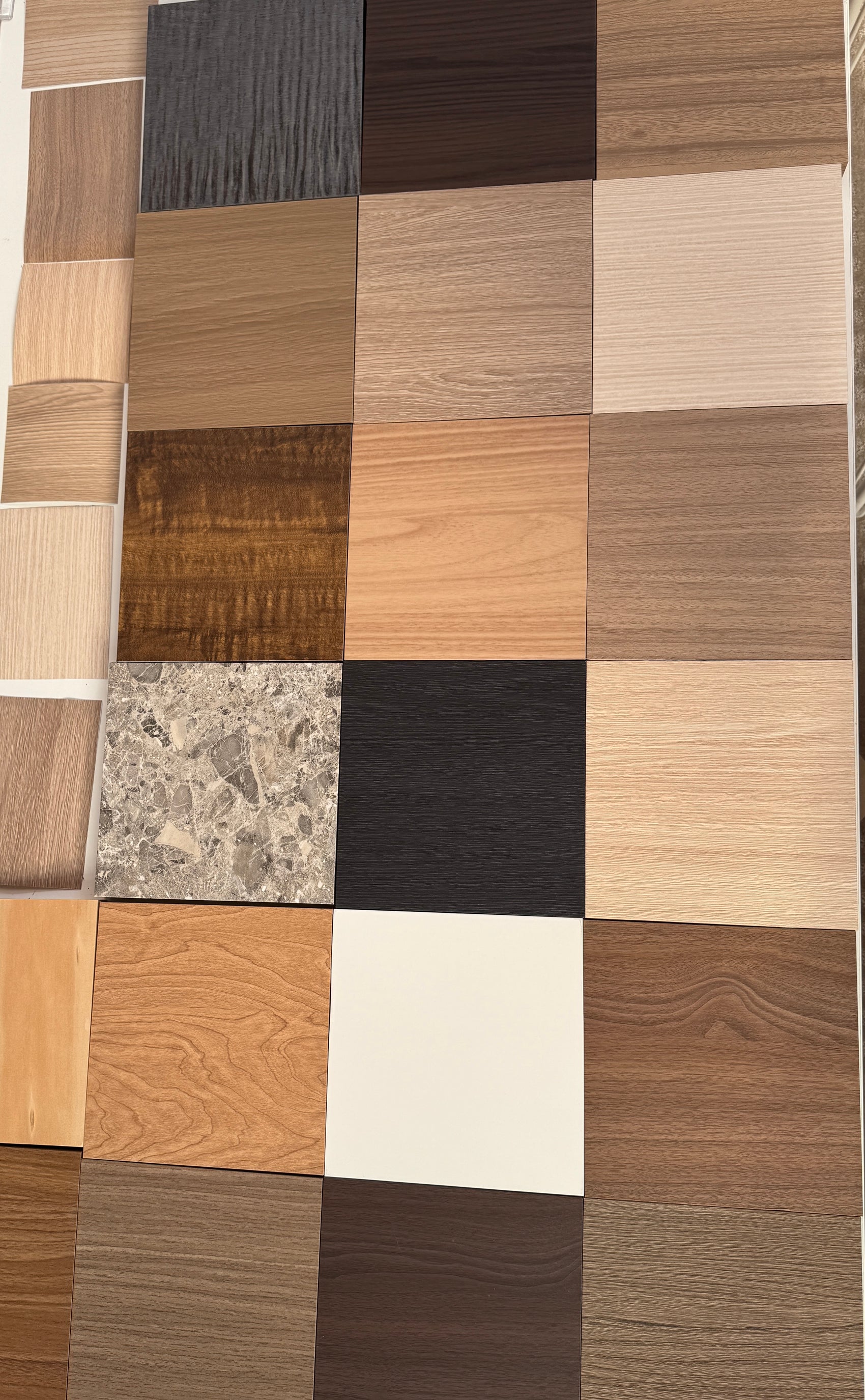 A grid of Velven A4 finish samples laid out together, timber, stone and solid colours