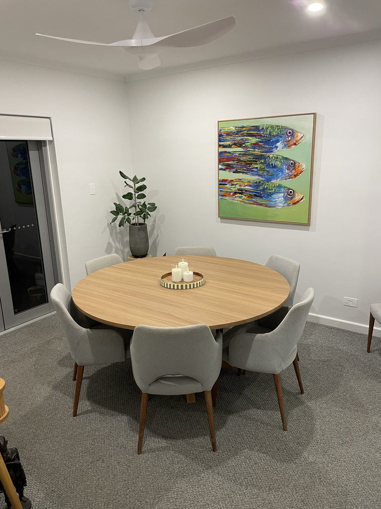 The same round dining table fully wrapped in Toasted Teak wood grain, set with chairs