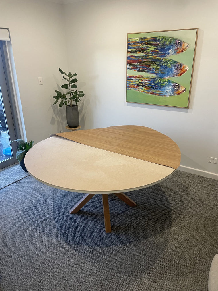 A pale round dining table half wrapped in Toasted Teak wood grain, partway through the job
