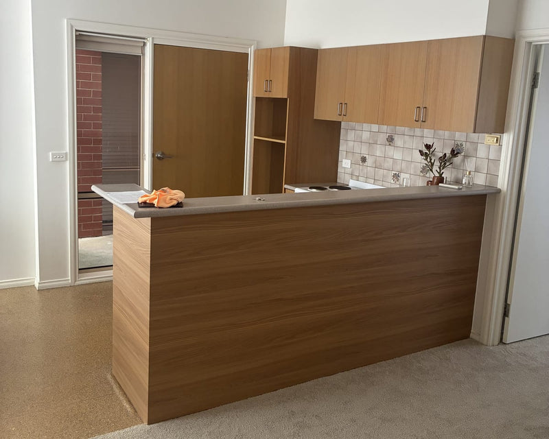 Customer kitchen island wrapped in Toasted Teak, a warm brown wood grain, with the original benchtop kept
